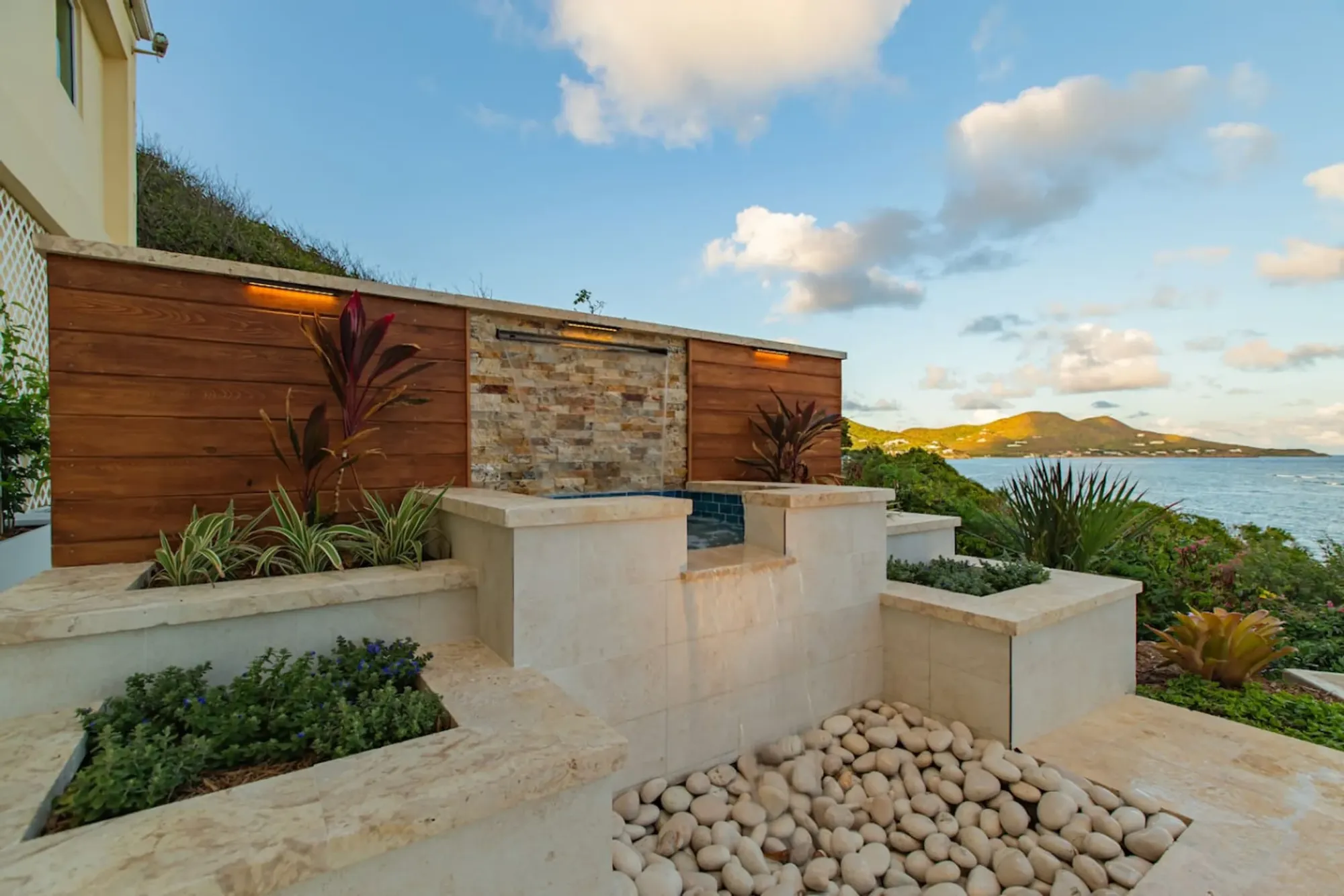 Fire-pit terrace and planters above the water at dusk