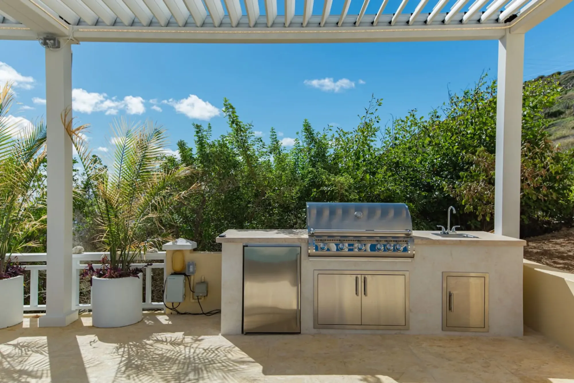 The outdoor kitchen and grill under a pergola