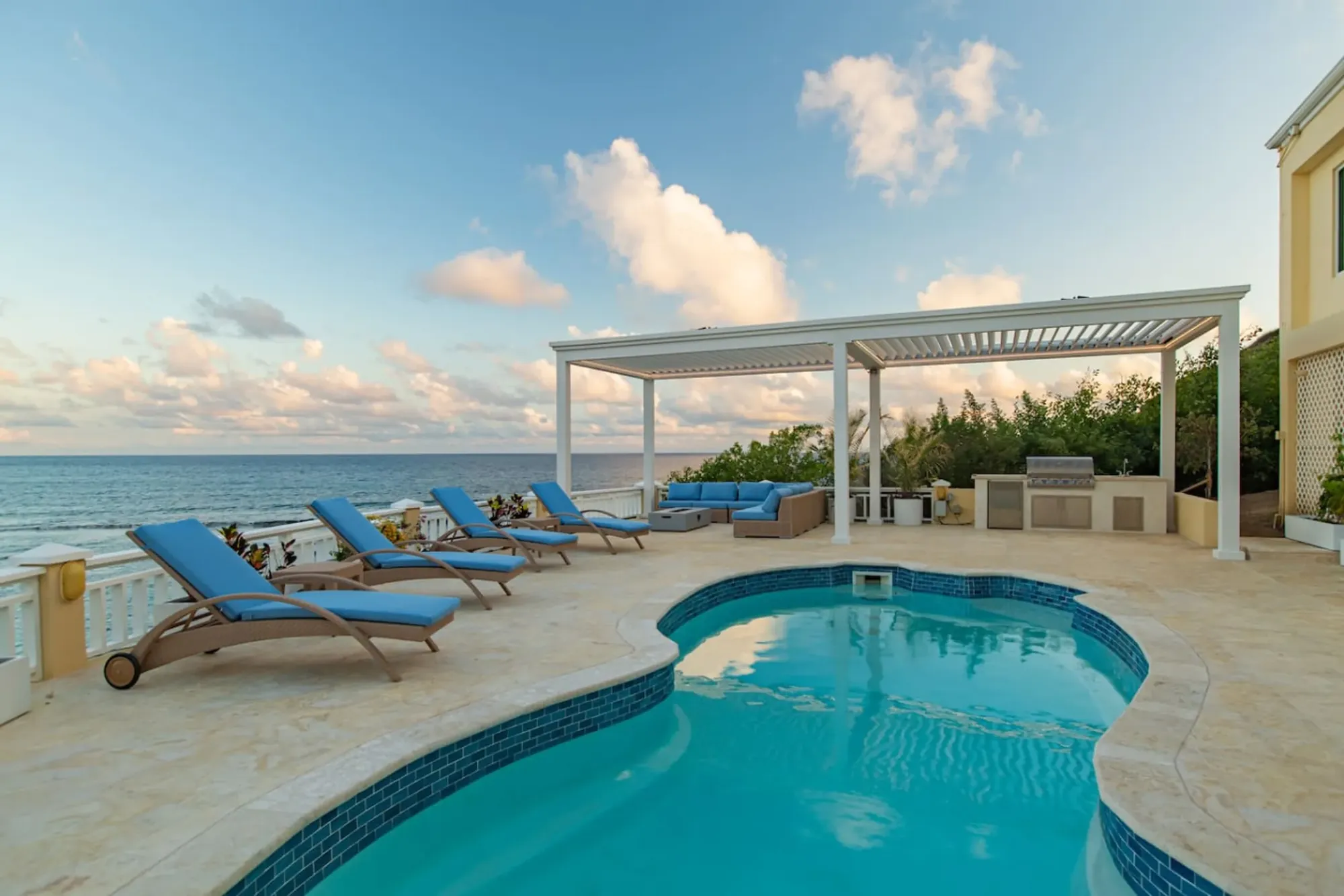 The turquoise pool and sun loungers under the pergola